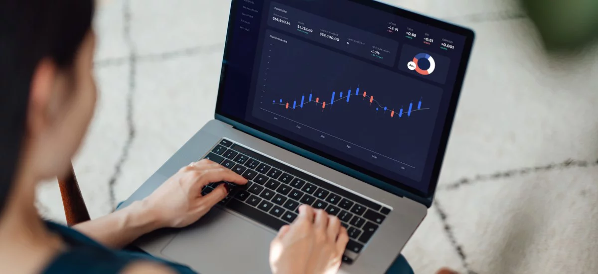 Woman trading stocks, cryptocurrency and managing financial investment on laptop