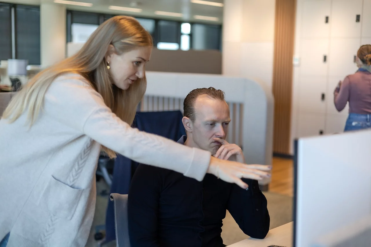 Twee medewerkers kijken met een peinzende uitdrukking naar het scherm.