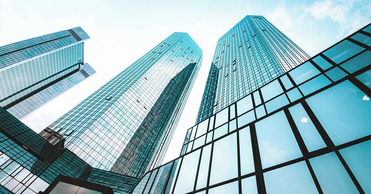 A skyline view featuring tall buildings with numerous windows reflecting sunlight.