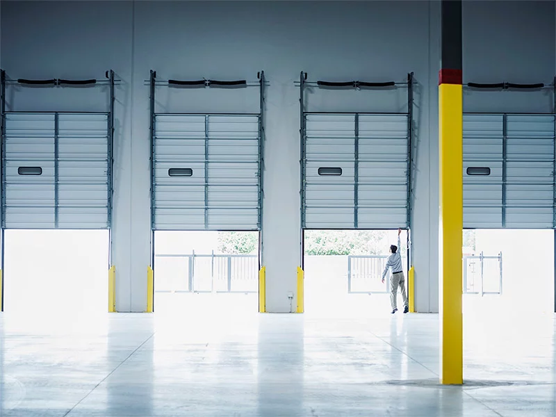 Man pulling down the hurricane shutter of warehouse
