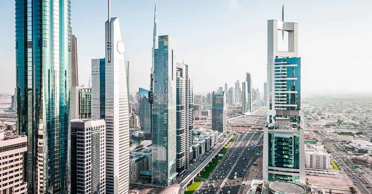 Aerial view of a city skyline featuring tall buildings against a clear blue sky.