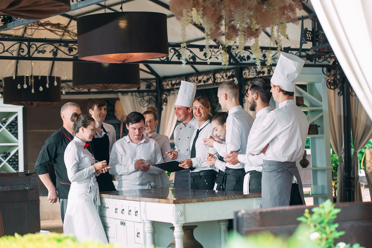 Restaurant manager and his staff in terrace. interacting to customer in restaurant