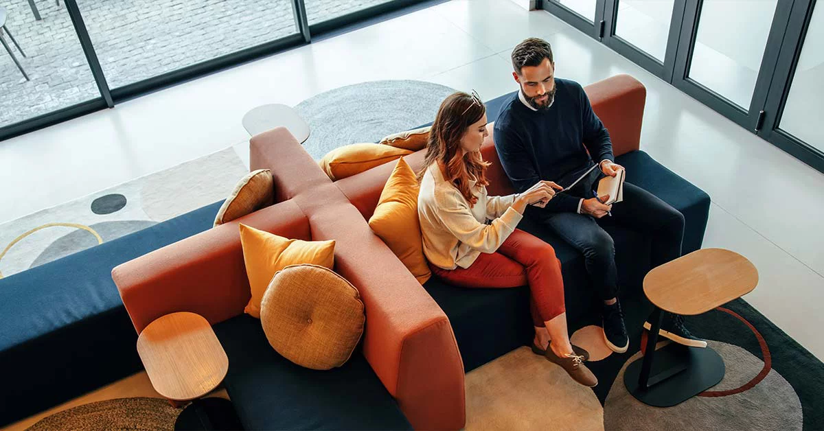 two persons sitting on a couch talking