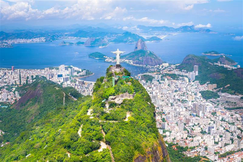 Vista aérea do Cristo Redentor, com a cidade do Rio de Janeiro ao fundo.