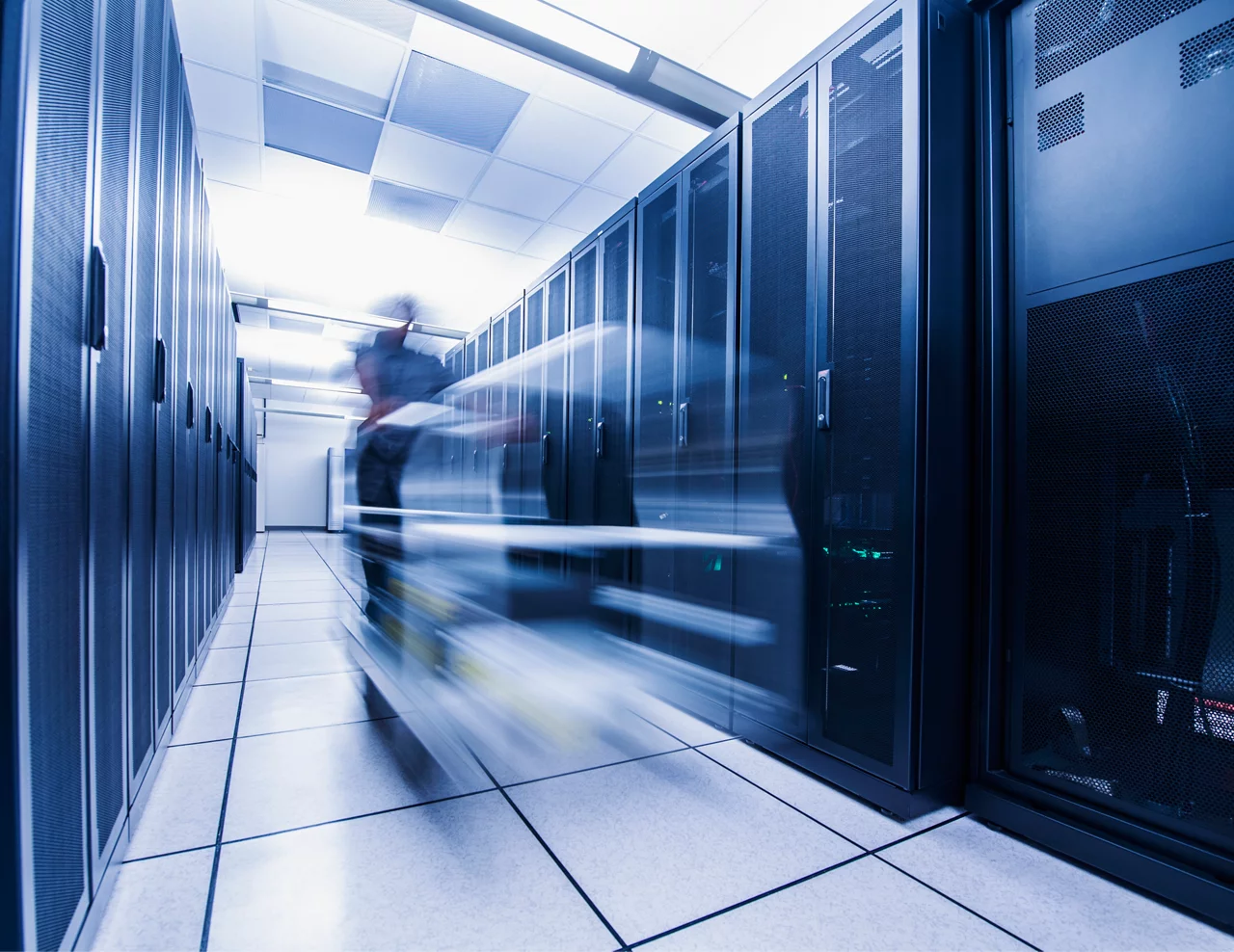 Long exposure of man pushing cart in server room