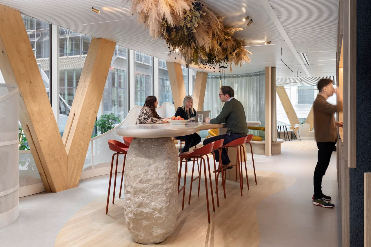 A modern office collaboration space featuring a distinctive high-top table