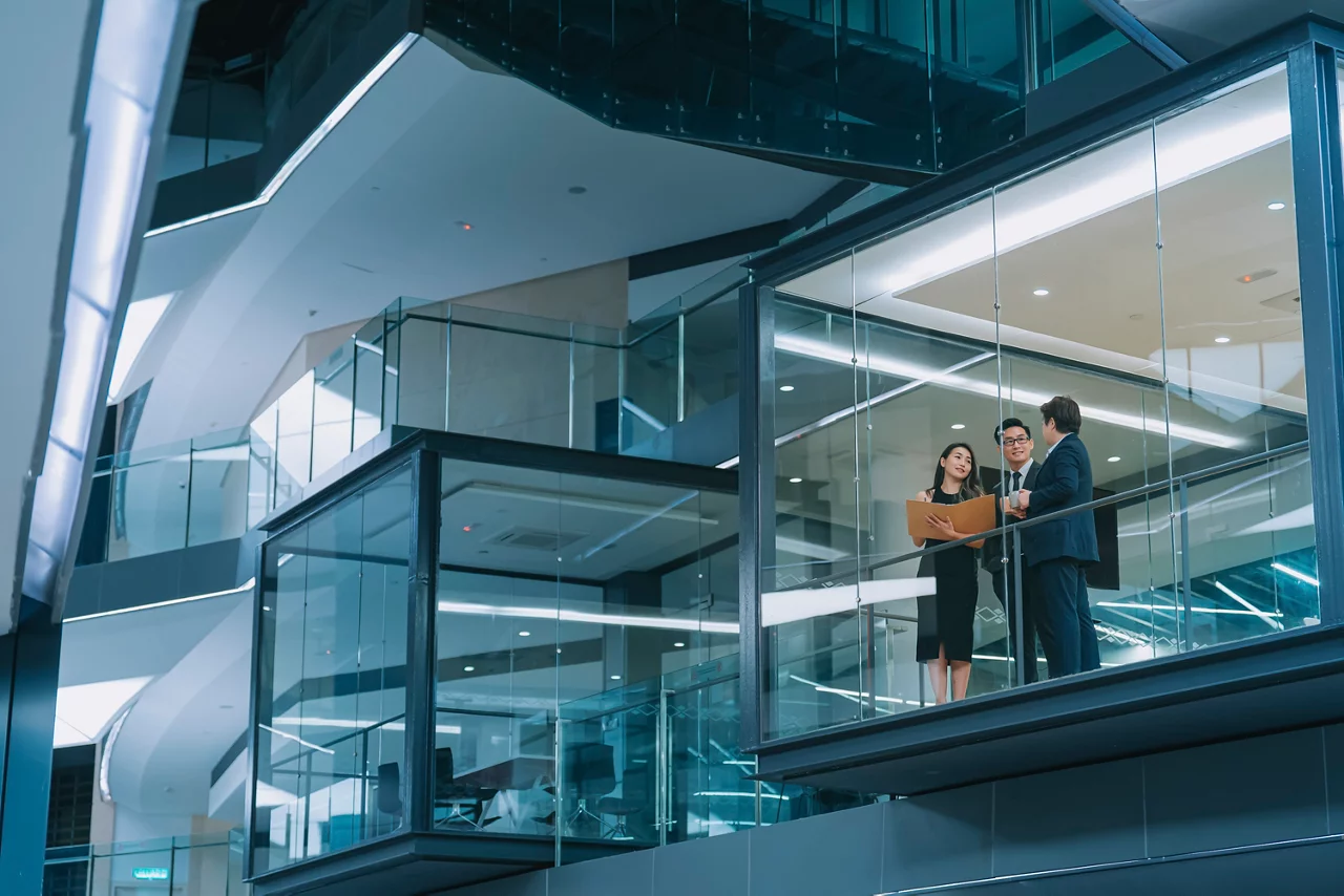 Office building exterior looking through window chinese business person meeting working late at night in meeting room
