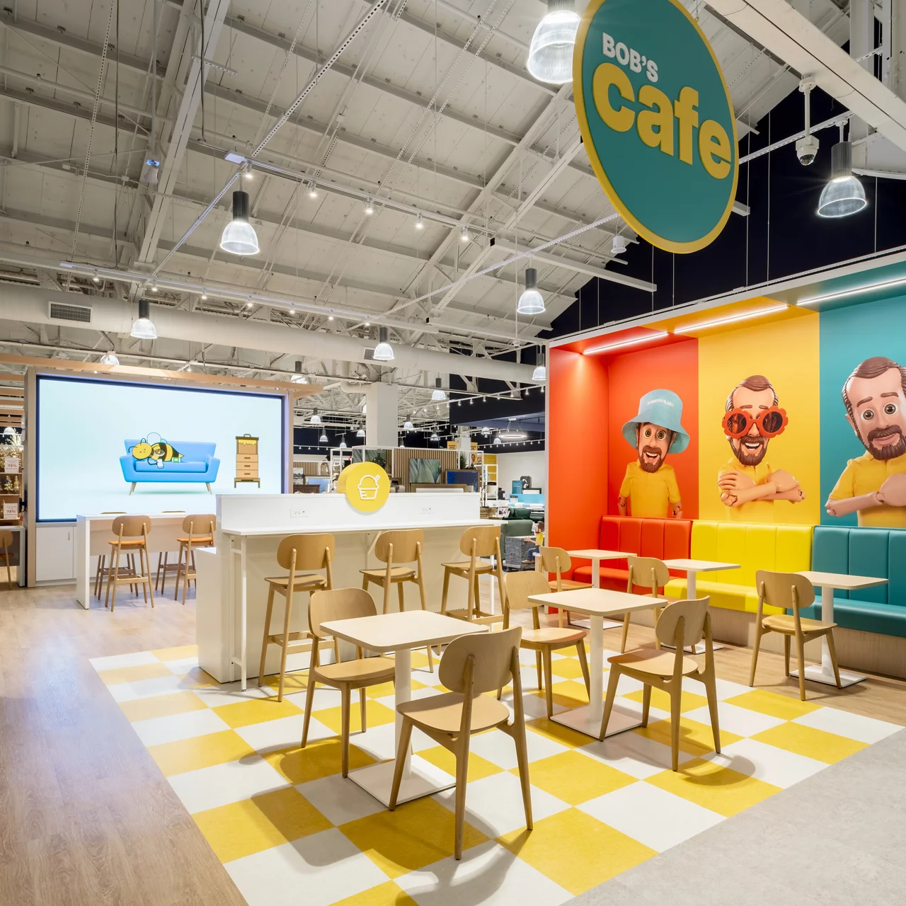 The vibrant "Bob's Cafe" area in a Bob's Discount Furniture store, featuring colorful mascot graphics and modern seating.