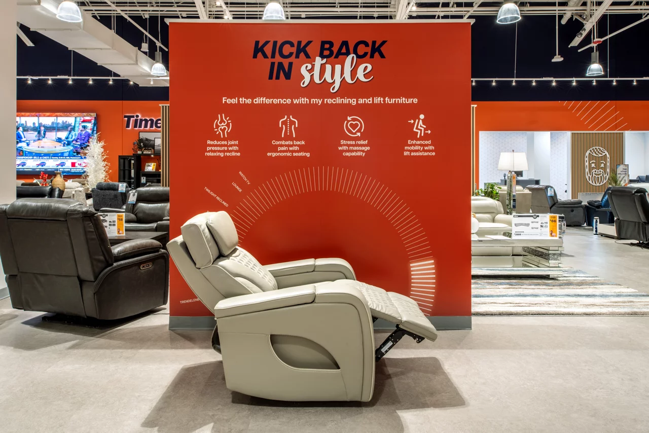 The interactive 'Design Desk' in a Bob's Discount Furniture store, with a large digital screen and customer seating.