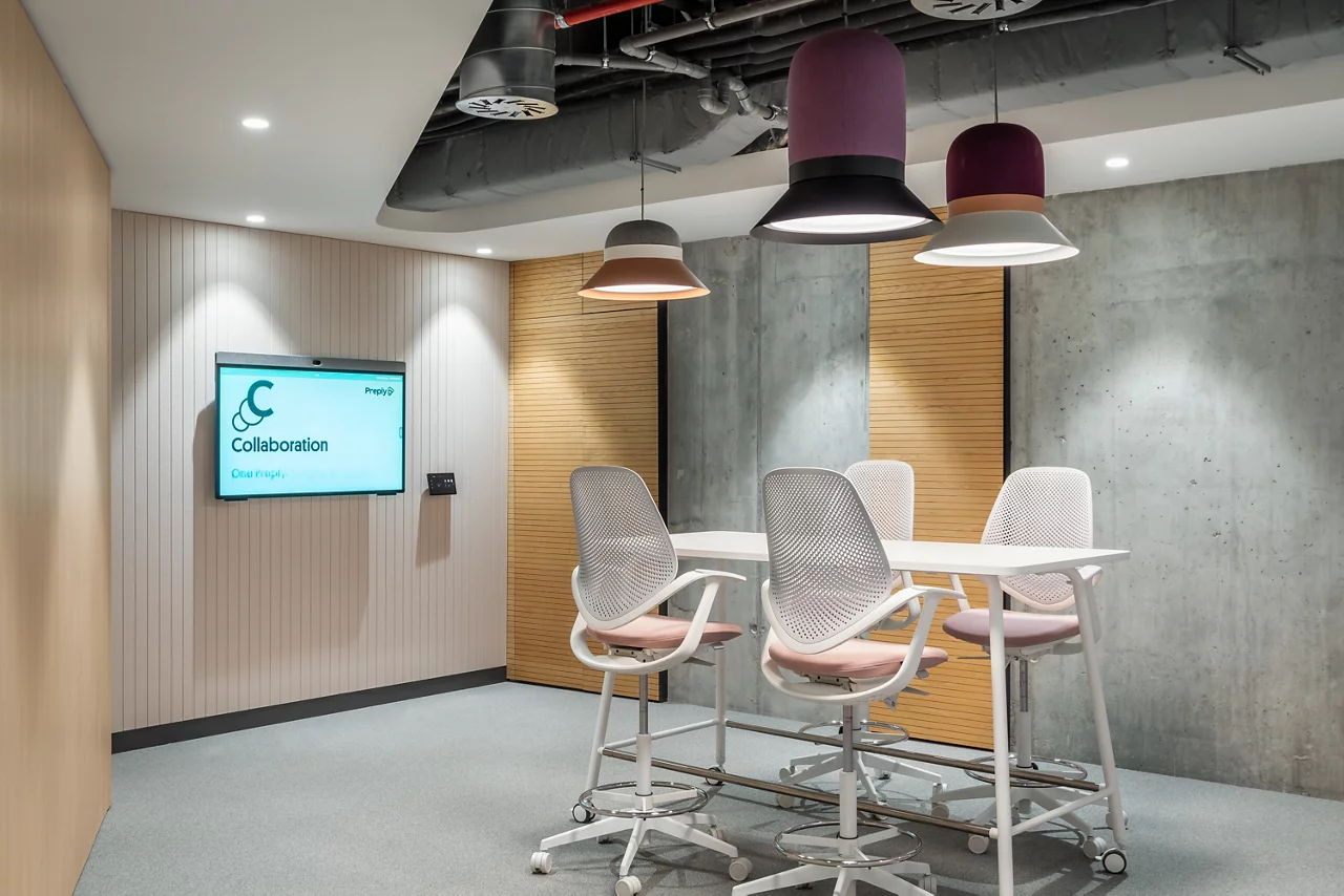 A colorful, playful common area in the Preply office, with stadium-style seating and the vision 'Power People's Progress'.