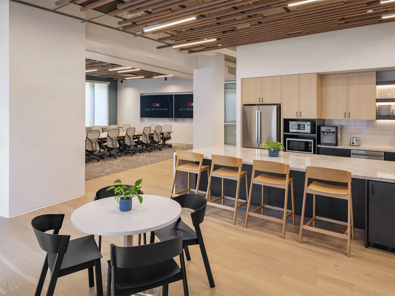 The modern kitchen and cafe at the JLL Walnut Creek office, with a view into the large conference room.