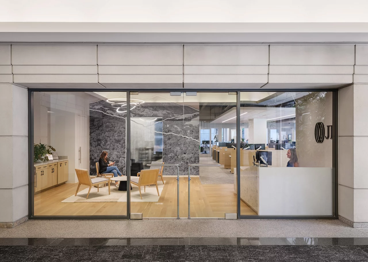 The glass storefront entrance of the JLL Walnut Creek office, showing the modern reception desk and lobby.