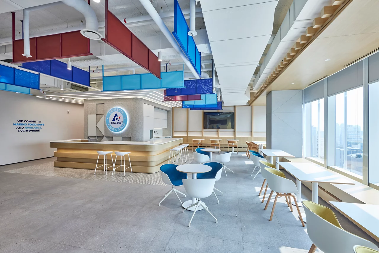The modern employee pantry and cafe at the Tetra Pak office, featuring a branded counter and colorful, contemporary seating.