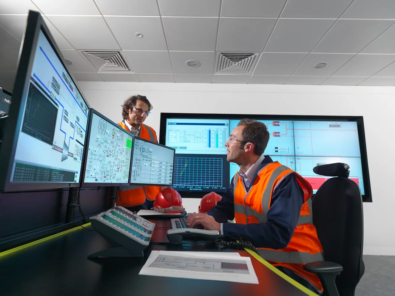 workers in control room with multiple computer