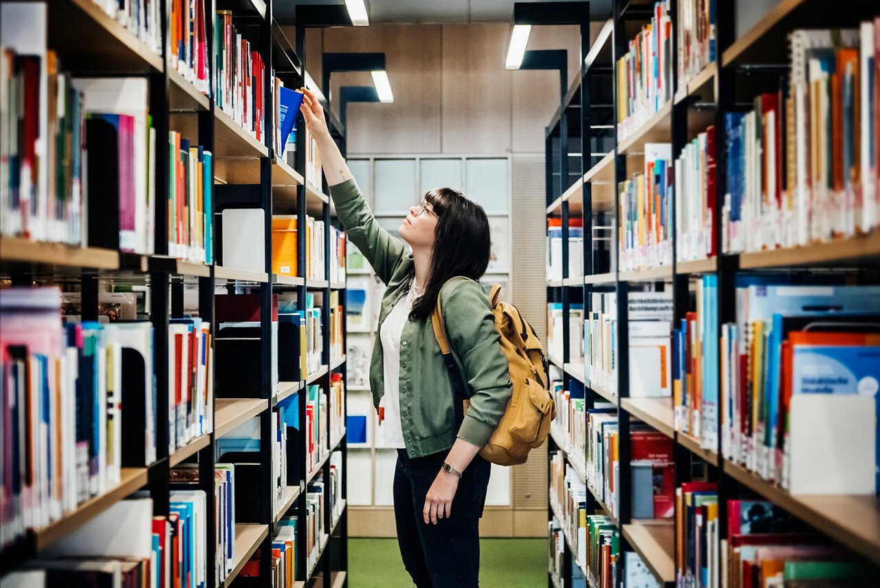 アダプティブ・リユースで整備された大学の図書館を利用する女子大生