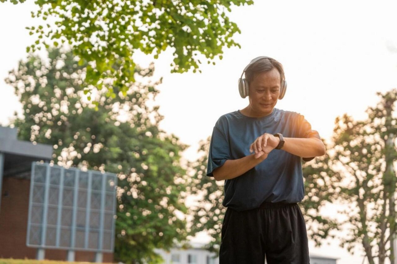 老人戴着耳机使用智能手表