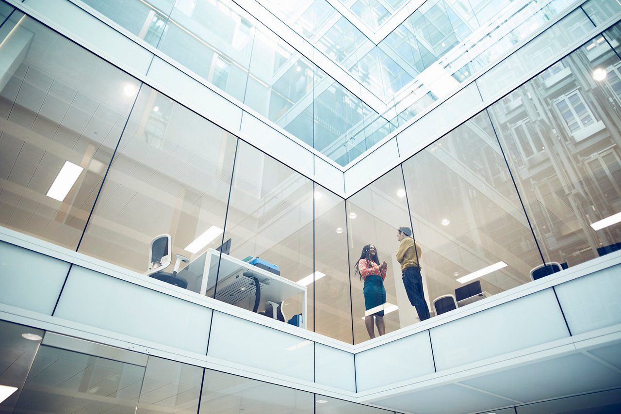 モダンなオフィスで会話する同僚