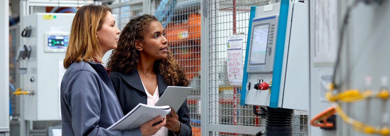 Duas mulheres olhando para um aparelho técnico