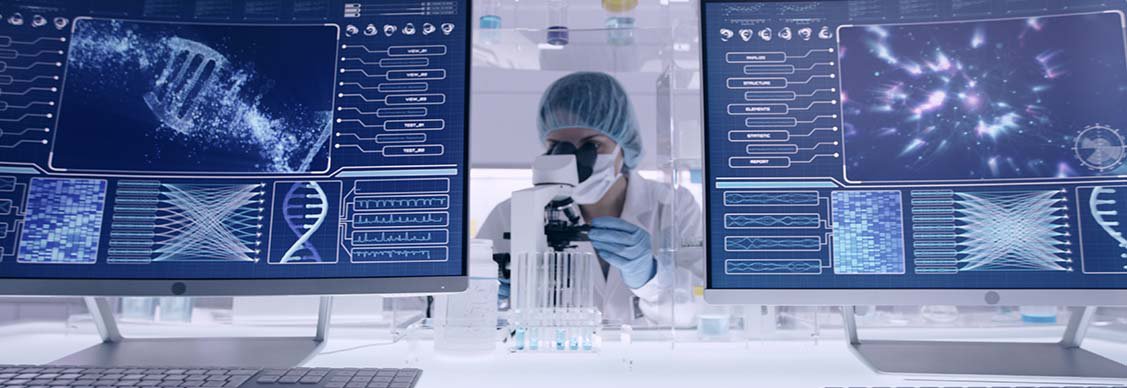 Lebenswissenschaftliches Labor mit einem Wissenschaftler, der zwischen zwei Computerbildschirmen, die wissenschaftliche Daten anzeigen, arbeitet.
