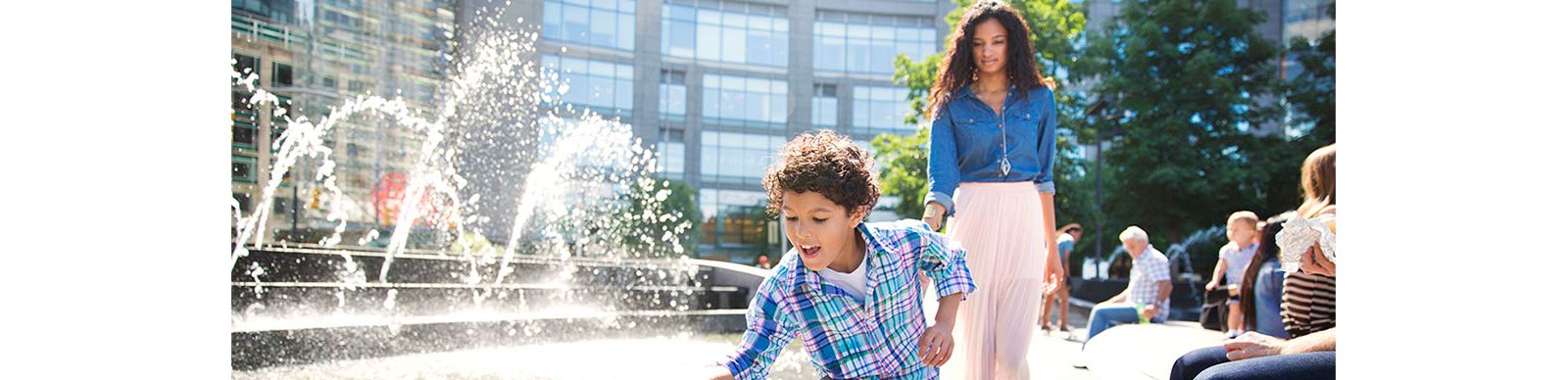 Playful boy with mother walking on footpath