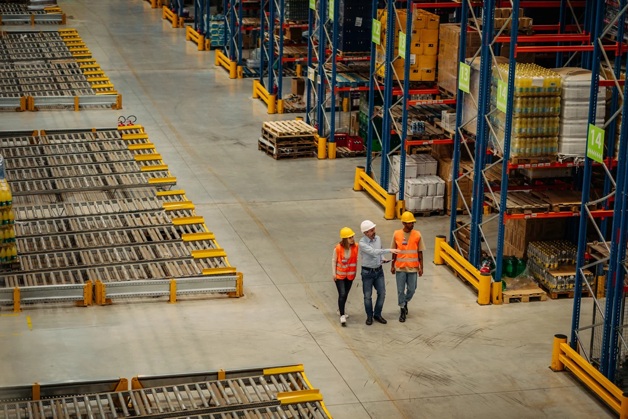 Warehouse employees walking through shelves and talking