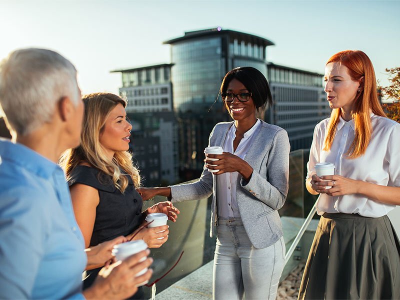 Four people discussing about something while drinking coffee
