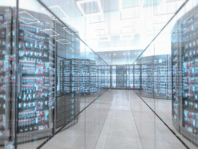 Data center server room in a large illuminated space with glass walls