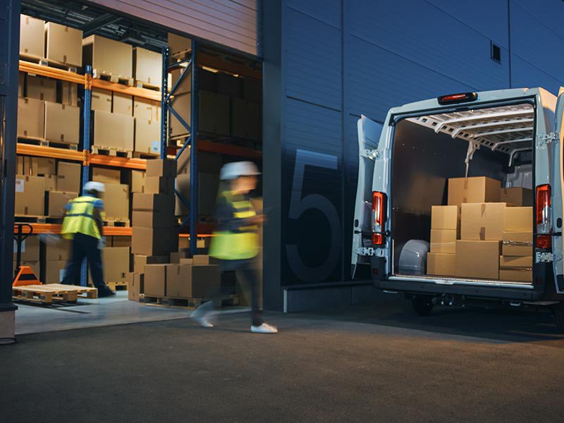 Workers Loading Delivery Truck with Cardboard Boxes