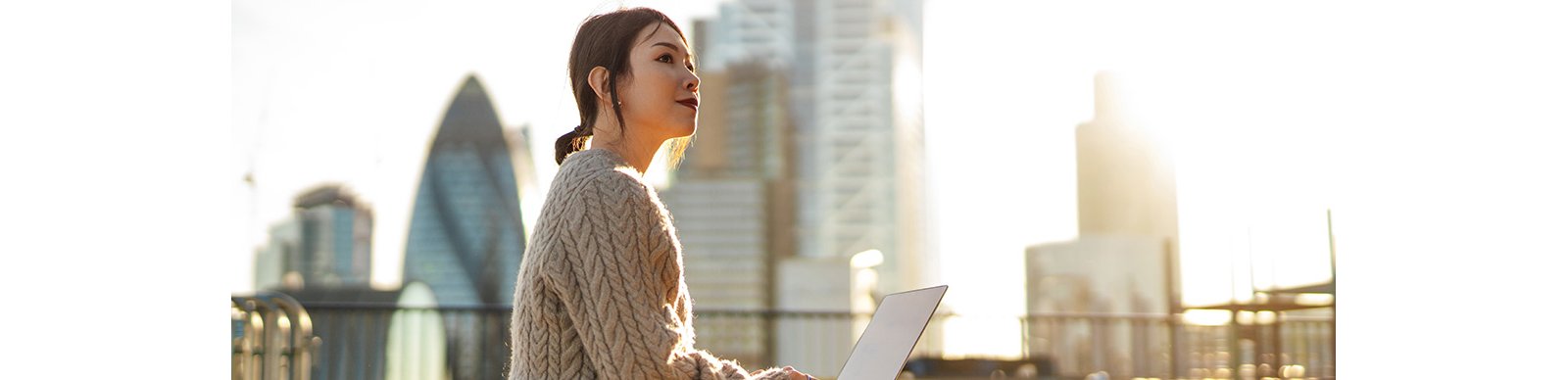 Young woman with laptop working on roof terrace
