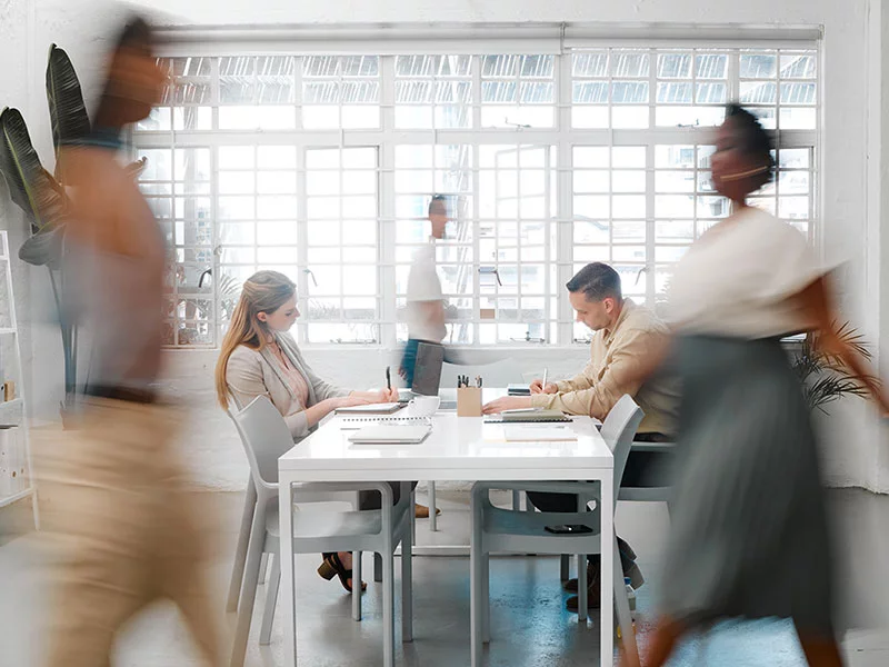 Business people at their desks in a busy, open plan office. Startup business people working at a modern office.