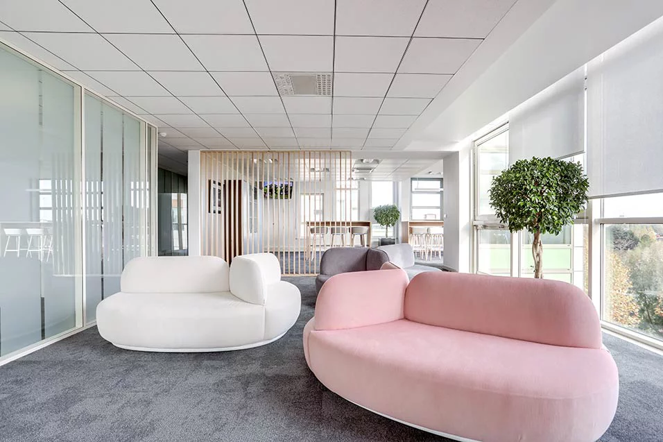 A modern office featuring pink and white furniture, creating a stylish and contemporary workspace environment.