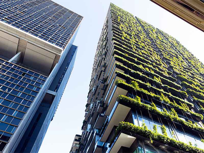 Low angle view of apartment building with vertical garden, sky background with copy space.