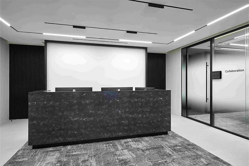 A monochrome photograph depicting a reception area, featuring sleek furniture and an inviting ambiance.
