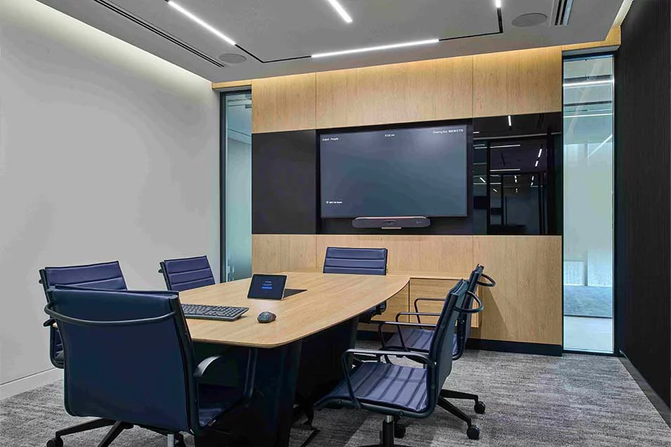 A spacious conference room equipped with a large screen and multiple chairs for participants.