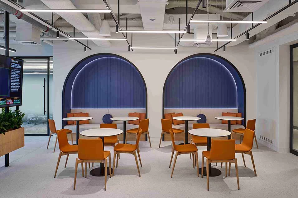 An office designed with stylish orange chairs and tables, contributing to a lively and energetic atmosphere for productivity.