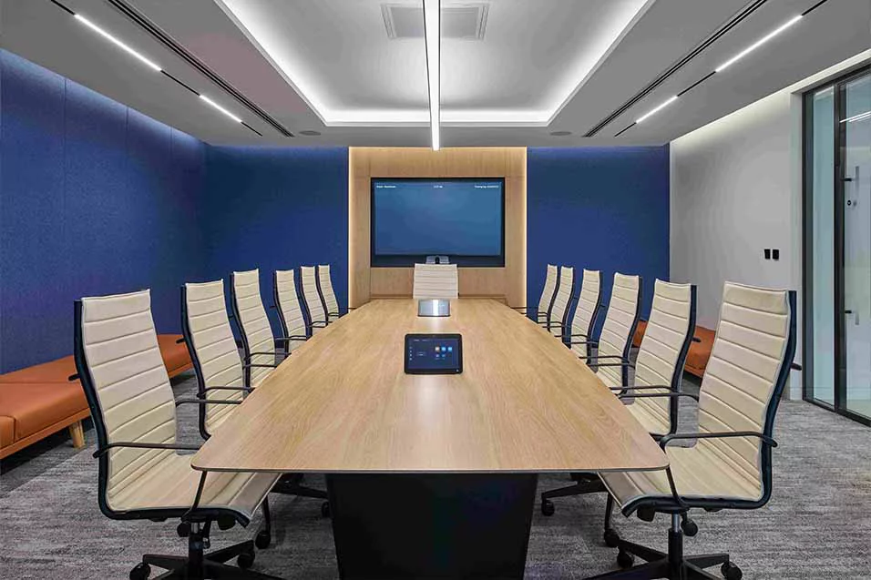 A spacious conference room equipped with a large screen and multiple chairs for participants.