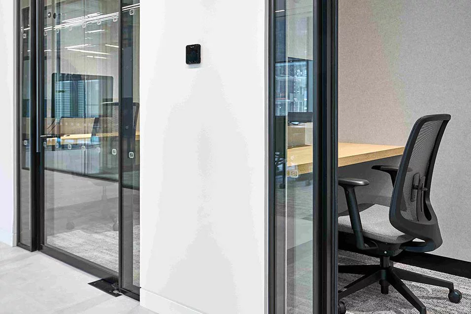 An office designed with glass walls and a minimalist desk