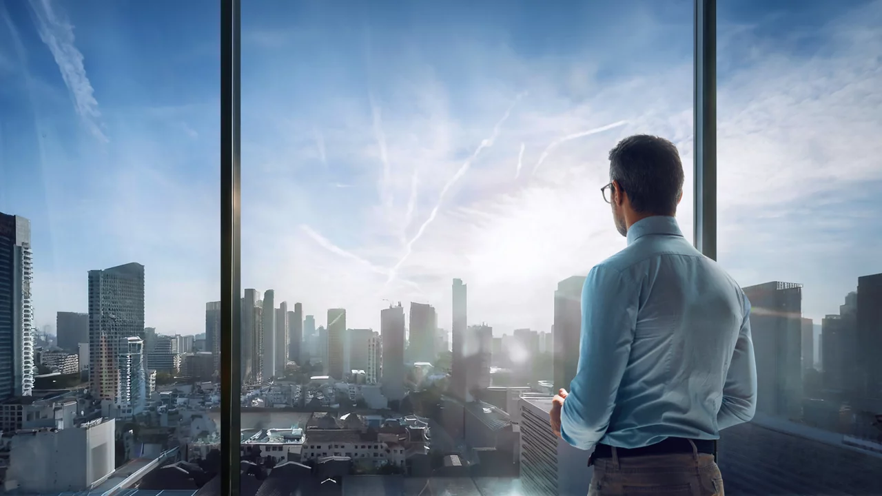 Man looking out skyscraper window