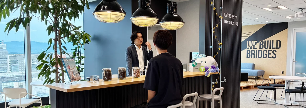KINTOテクノロジーズの福岡オフィスのカフェスペースで談笑する2人