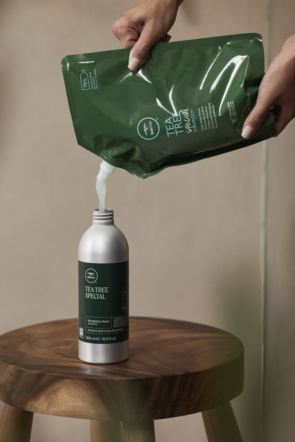 image of a person pouring Tea Tree Special Shampoo from a refill package into a bottle