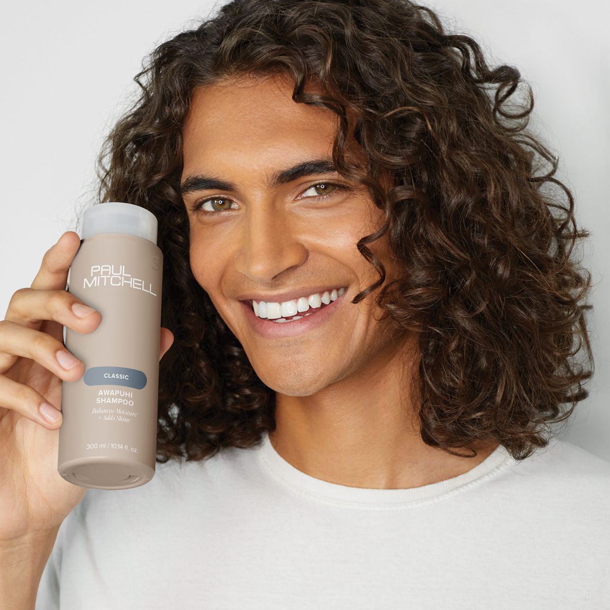 image of a model holding a bottle of Awapuhi Shampoo