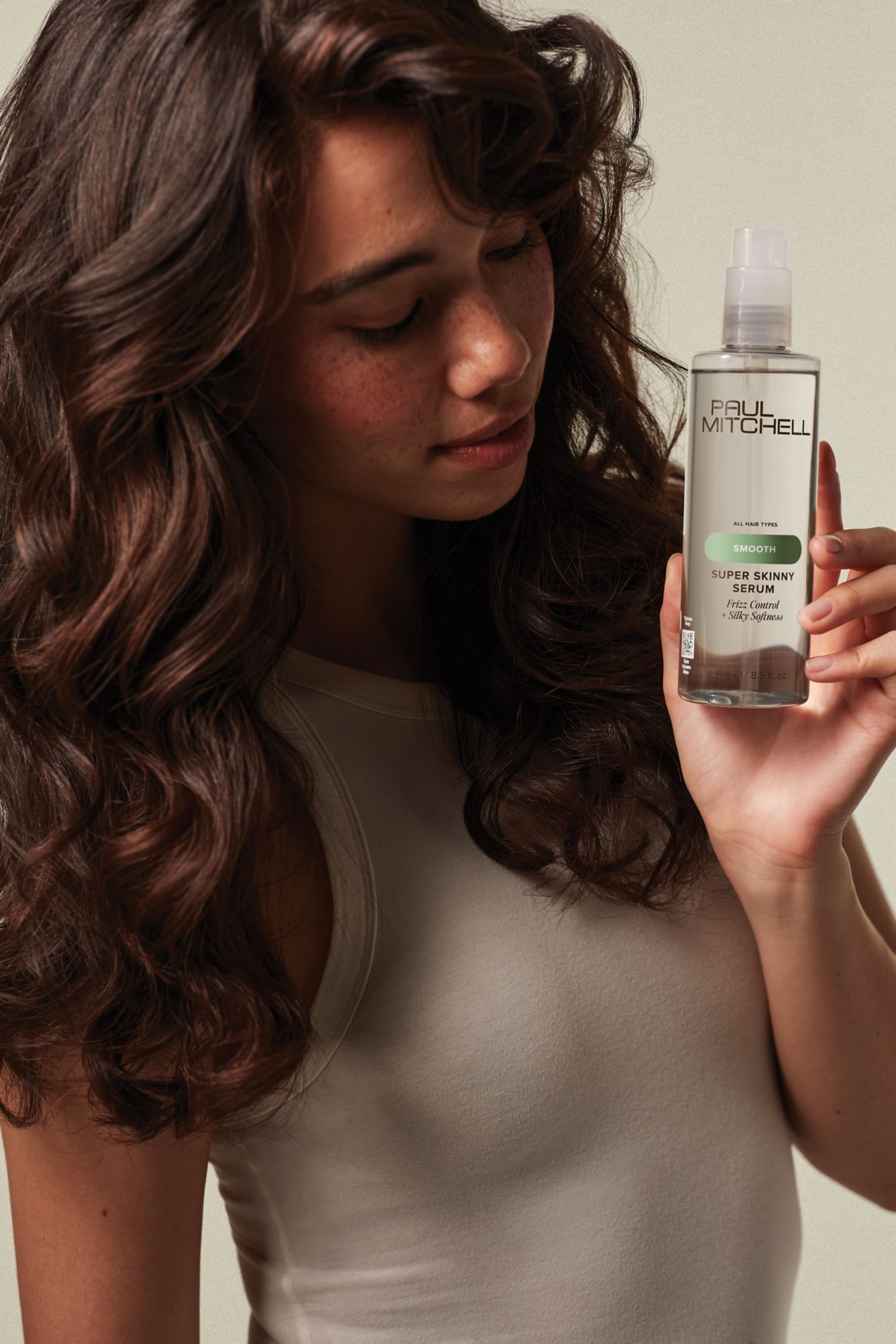 image of a model holding a bottle of Super Skinny Serum