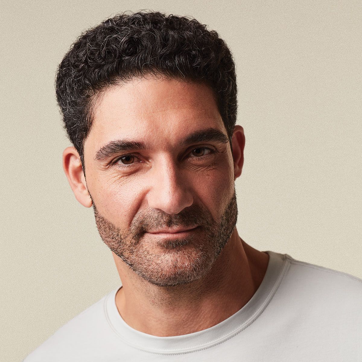 a man with dark hair in a short messy textured style