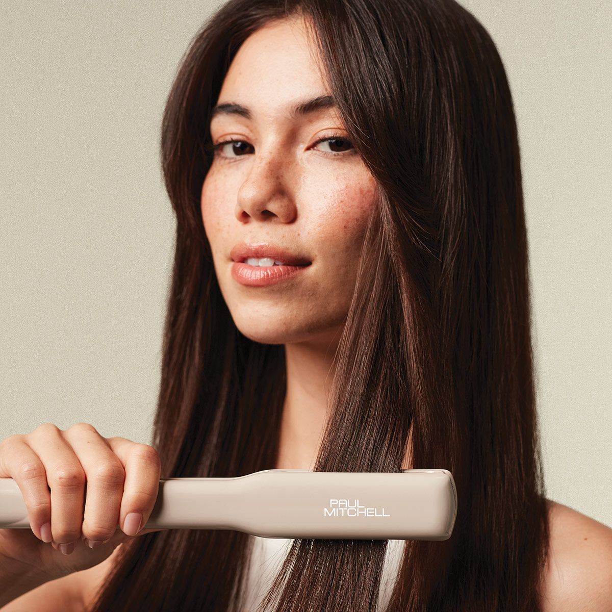 image of a model holding the Paul Mitchell Smooth+ Ceramic Flat Iron