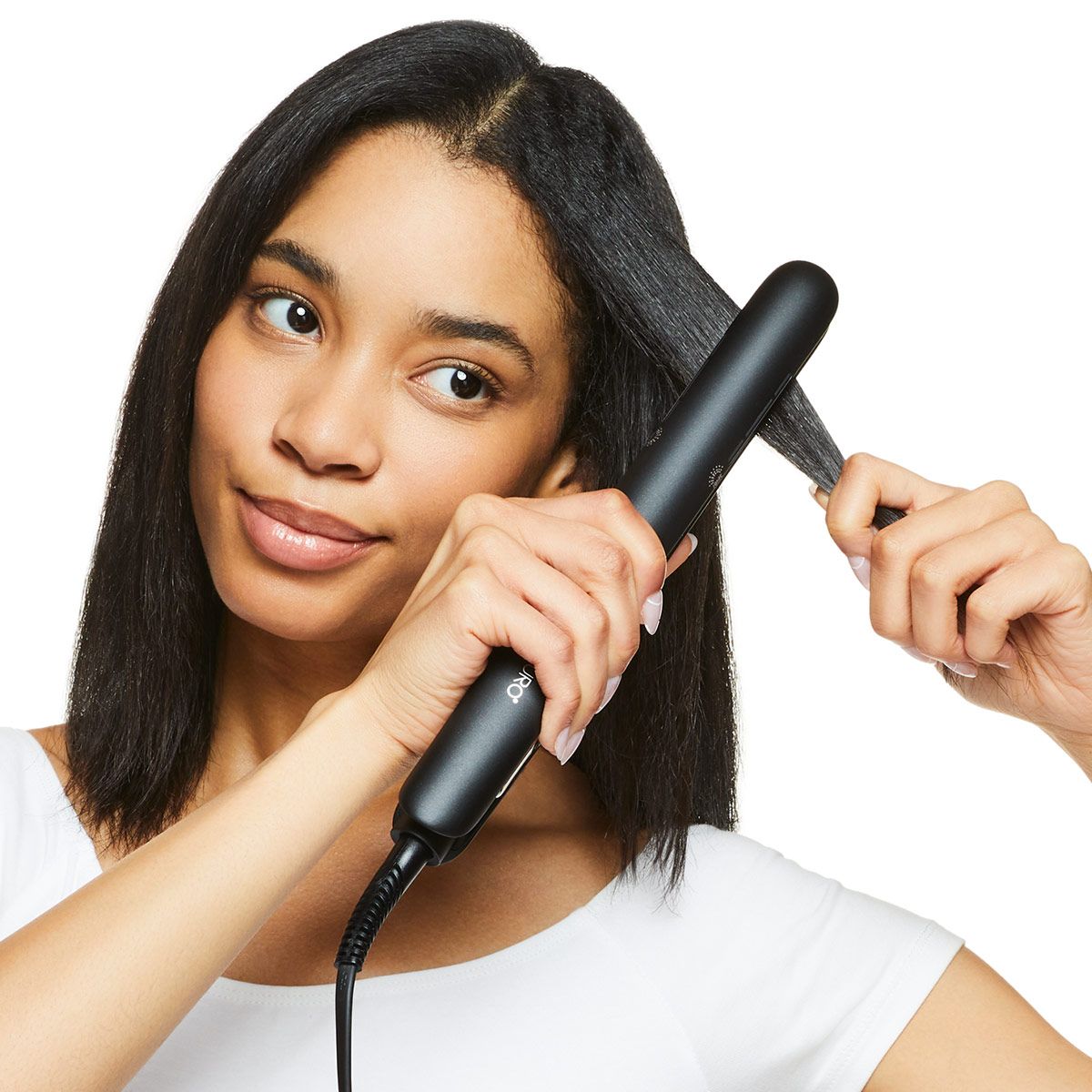 image of a woman straightening her hair with a flat iron