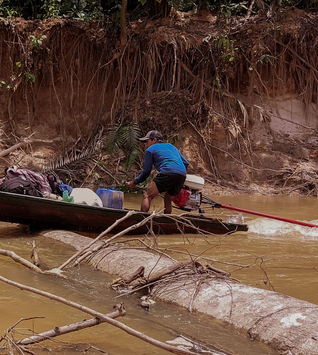 image of a man steering a boat down a river
