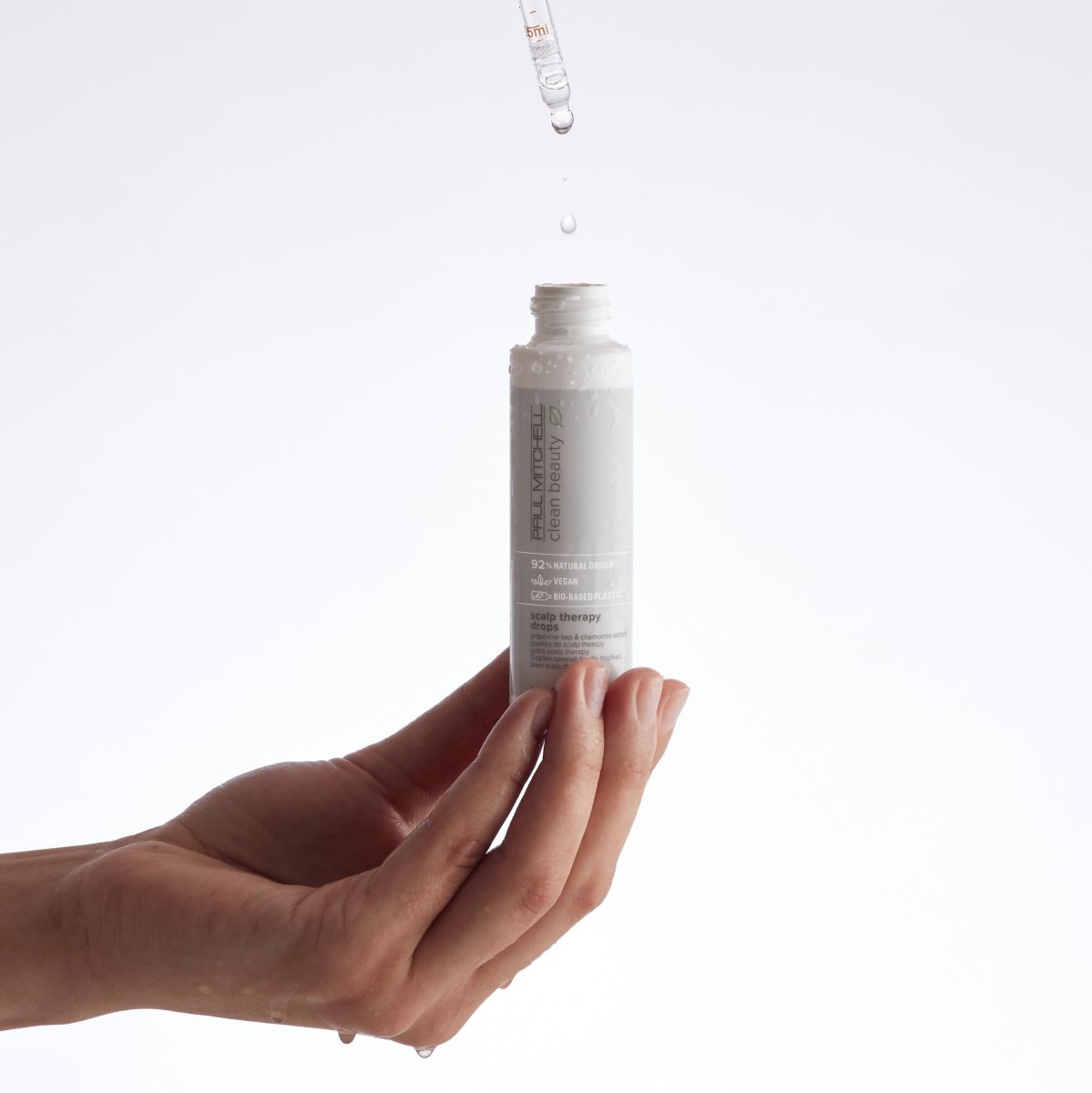 image of a model holding a bottle of Clean Beauty Scalp Therapy Drops