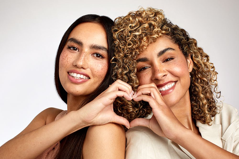 image of two women joining their hands to create a heart
