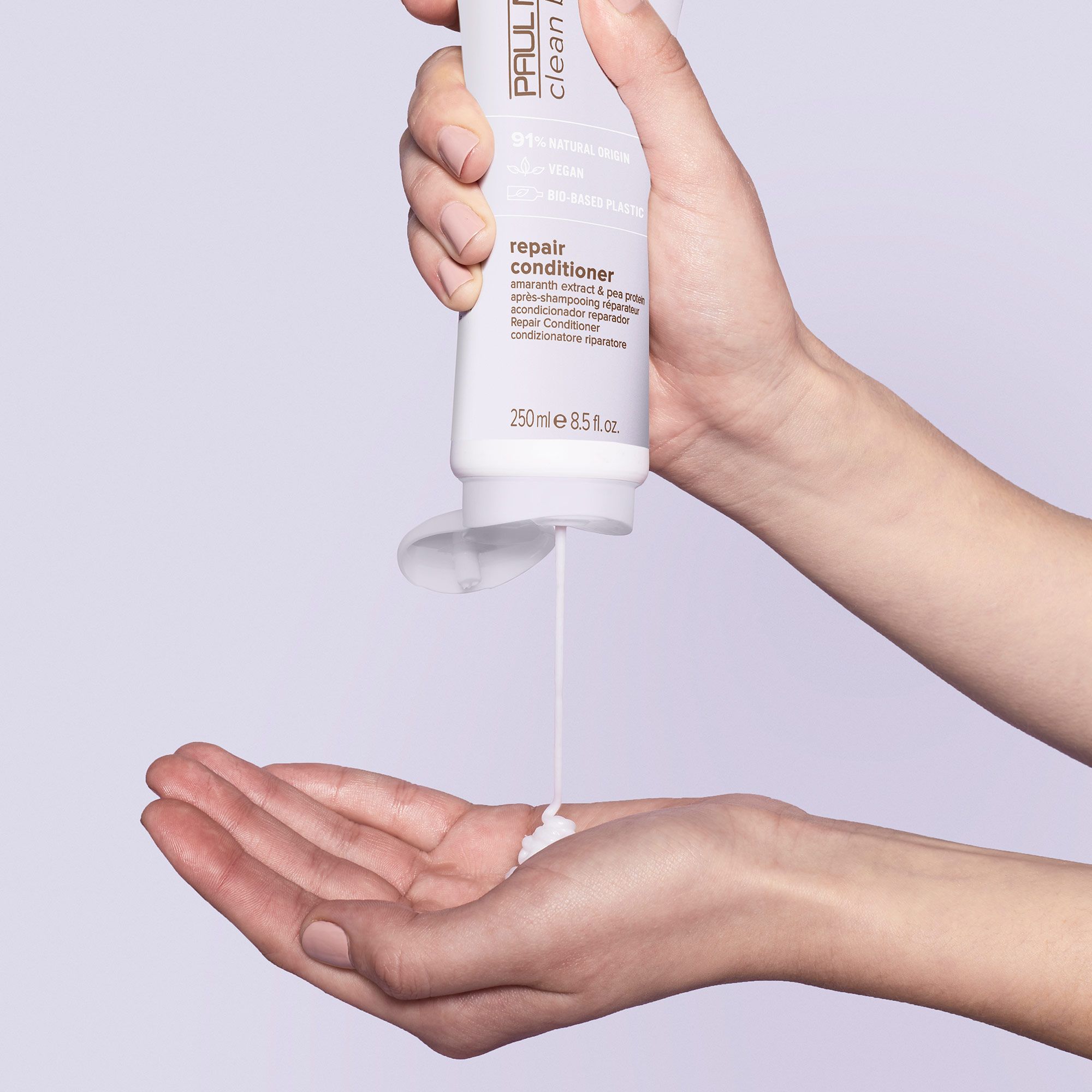 a model holding a bottle of Clean Beauty Repair Conditioner