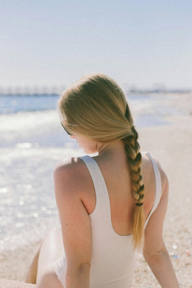 Woman on the beach with a three-strand braid for thin hair